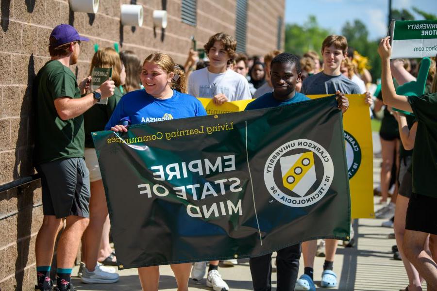 A photo of the fall 2024 empire state of mind living learning community holding a banner